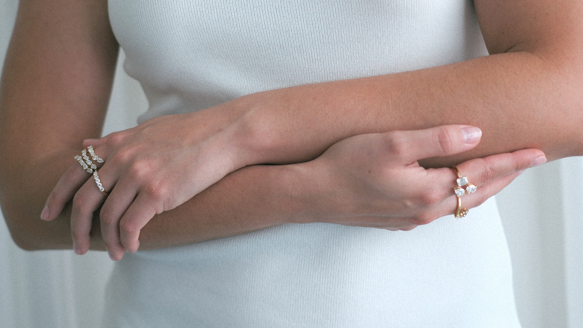 Close-up of two hands with jewelry on a white background