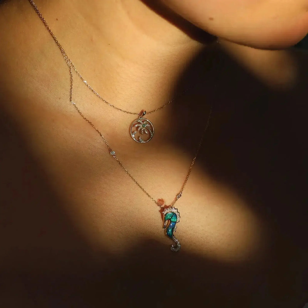 Beautiful model wearing a palm tree necklace and a seahorse pendant